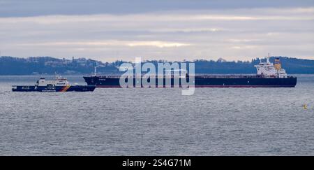Sassnitz, Germany. 12th Jan, 2025. The unmaneuverable tanker "Eventin" lies in the roadstead off Sassnitz, with the Baltic seaside resort of Göhren in the background. The federal police vessel BP82 "Bamberg" is sailing in front of the oil tanker. Credit: Stefan Sauer/dpa/Alamy Live News Stock Photo