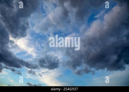 Detail of blue sky at dusk with fluffy white and gray cumulus clouds Stock Photo