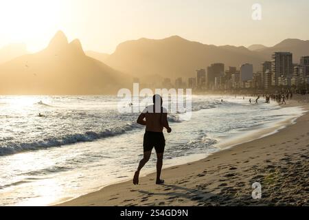 Jogger at Ipanema Beach in Rio de Janeiro during dramatic sunset Stock Photo