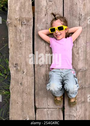 A girl lying on boards and looking at the sky Stock Photo