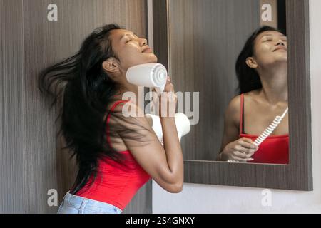 Smiling woman has enjoy from blow drying with flying hair Stock Photo