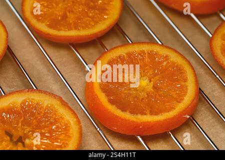close up of candied orange slice on draining rack, homemade winter snack made from organic oranges and sugar Stock Photo