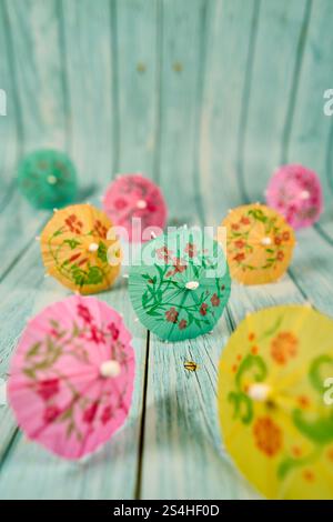 Multicolored cocktail umbrellas with flower patterns on wood Stock Photo