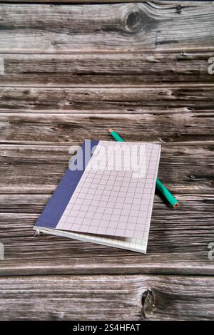 Notepad with crossed and parallel lines along with a pencil on a wooden desk.  Stock Photo