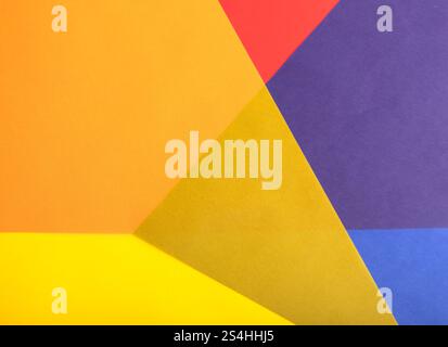 Colorful geometric paper background with translucent red, yellow, orange, blue, and purple overlapping layers. Multicolored shapes and vibrant contras Stock Photo