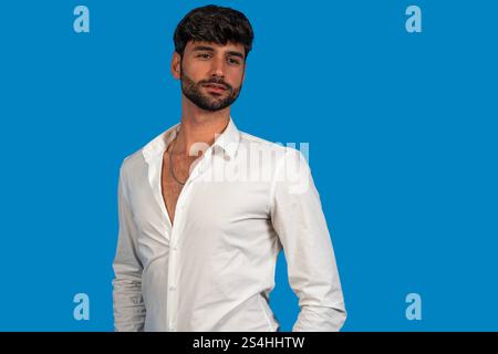 Studio shot of young, attractive man with open white shirt and necklace, exuding confidence and style Stock Photo