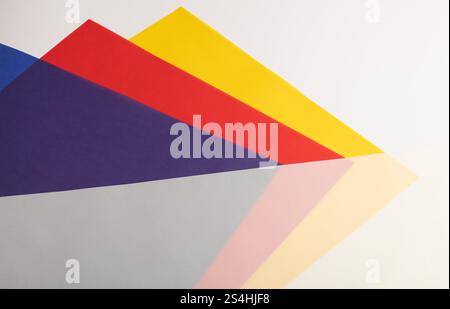 Layered paper background with translucent red, yellow, blue, and purple sheets. Bold pastel tones and overlapping gradients create a dynamic, vibrant, Stock Photo