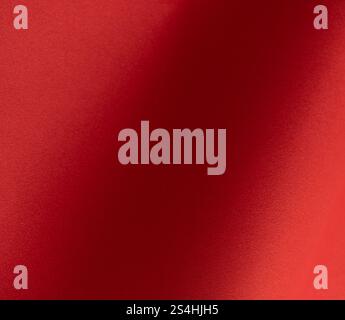 Red paper background with fiery tones and a soft matte gradient. Warm and vibrant hues blend seamlessly with smooth textures, deep shadows, and a stri Stock Photo