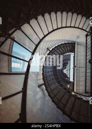 View looking down a spiral staircase in a lighthouse Stock Photo