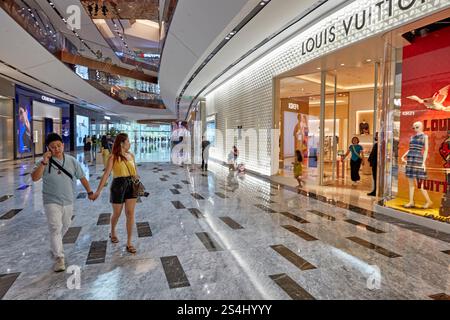 Man and woman walk together holding hands in the Exchange TRX, an upscale shopping mall in Kuala Lumpur, Malaysia. Stock Photo