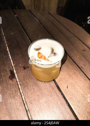 Whiskey Sour cocktail in a round glass on a table. Flashlight Stock Photo