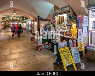 Cuneo, Italy - December 12, 2024: Newspaper kiosk for sale under the historical arcades of Via Roma in the centre of Cuneo Stock Photo