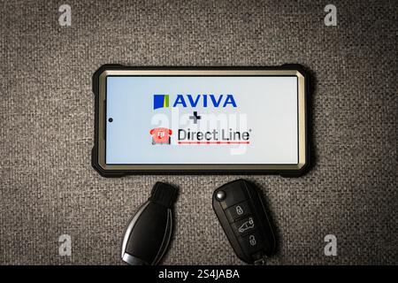 Aviva is acquiring Direct Line insurance company, as shown on smartphone screen with car keys Stock Photo