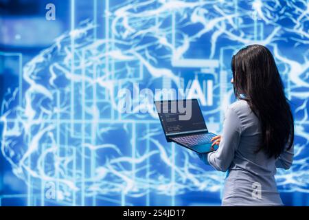 Computer scientist working on laptop, programming artificial intelligence computing simulating human brain. Woman using notebook, developing AI machine learning algorithms Stock Photo