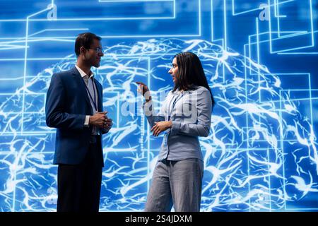 Engineering team colleagues doing brainstorming, analyzing AI models. Coworkers discussing, using machine learning to better understand and develop artificial intelligence Stock Photo