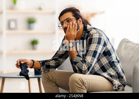 Upset middle-eastern guy got bored while playing video games Stock Photo