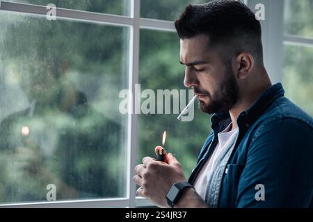 Urban lifestyle, emotional portrait of young handsome man sad and depressed, smoking Stock Photo