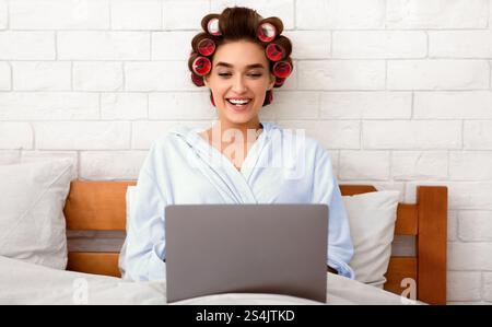 Happy Glamorous Lady Using Laptop Computer Working Online In Bedroom Stock Photo
