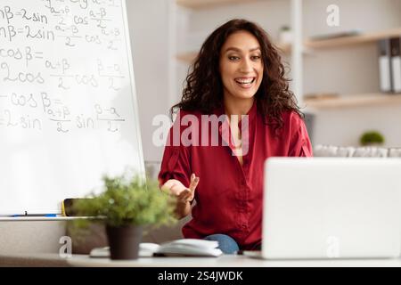 Smiling lady teacher explaining trigonometric functions to students online Stock Photo