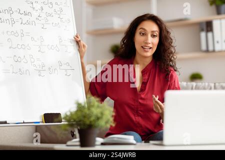 Lady teacher explaining trigonometric functions to students online Stock Photo