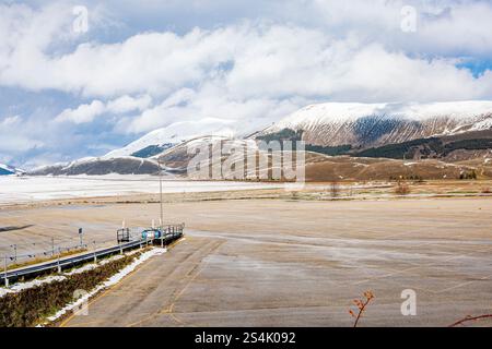 A stunning view of Roccaraso, Italy, with snow-covered mountains in the background. The vast open area and dramatic sky showcase the serene beauty Stock Photo