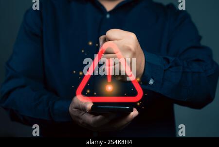 Man using smartphone with warning sign.Notification error and virus detection spyware. Emergency warning alert alarm on smartphone. Data network prote Stock Photo