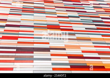Pattern of rectangular tiles arranged in a grid like fashion, with each tile varying in color. Colors range from shades of red, orange to white and gr Stock Photo