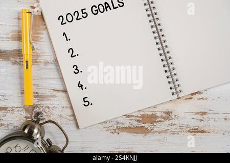 Goals concept. Notebook with goals list, cup of tea on wooden table. Motivation strategy write idea success solution concept. Top view. Retro toned im Stock Photo