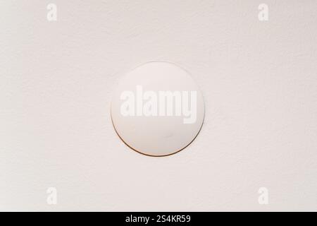 The junction box cover that covers the cables on the cream colored wall Stock Photo