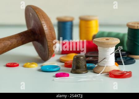 Sewing items - thimble, needle, measuring tape, spools of thread Stock Photo