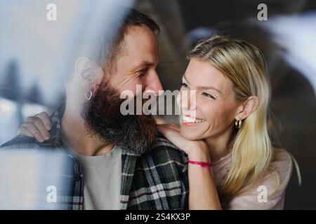 Mature couple spending Valentines weekend in the mountains in cabin. Husband and wife looking at each other lovingly. Stock Photo