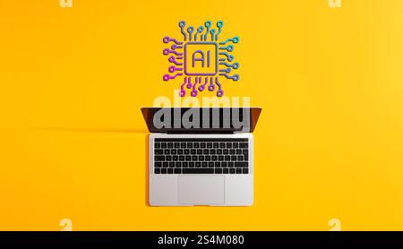 Open laptop displaying artificial intelligence chip hovering above it on vibrant yellow background, representing machine learning and ai technology Stock Photo