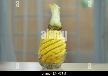 Organic Pineapple Decoratively Peeled and Presented in Glass Bowl on Wooden Table Stock Photo