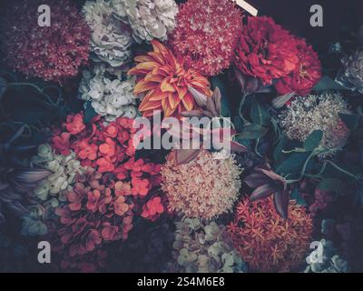 Vintage-styled image showcasing a vibrant array of artificial flowers, possibly a Chinese New Year decoration.  The blossoms are densely arranged, cre Stock Photo