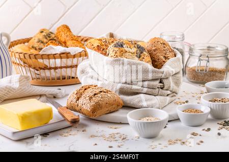 Variation of bread rolls or buns in breadbag  with butter and assorted seeds Stock Photo