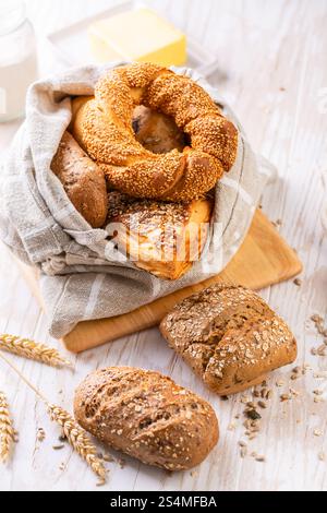 Variation of bread rolls or buns in breadbag  with butter and assorted seeds Stock Photo