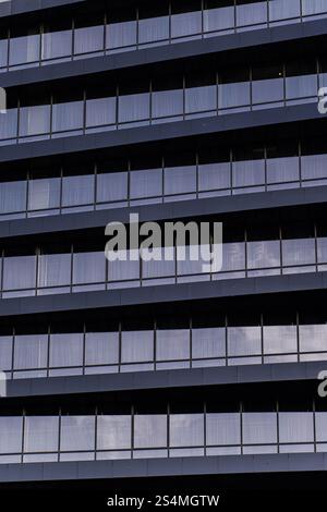 A detailed close-up showcasing the modern architectural design of a building's exterior. The image emphasizes the repetitive patterns and minimalist a Stock Photo