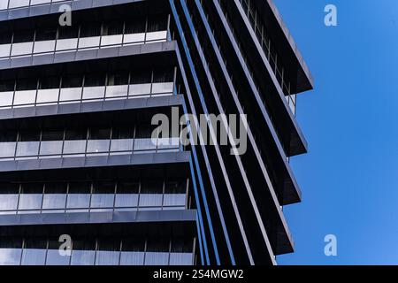 From below image highlights the geometric details of a modern skyscraper. The repeating patterns and sharp lines contrast dramatically against a clear Stock Photo