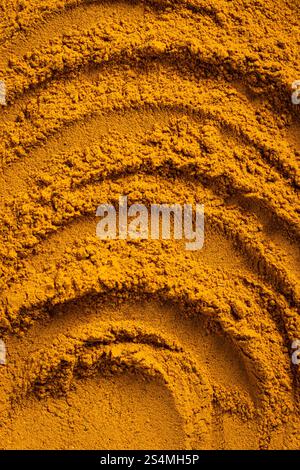 A vibrant close-up of golden curry powder, showcasing its textured surface with swirling patterns This aromatic spice is perfect as an ingredient for Stock Photo
