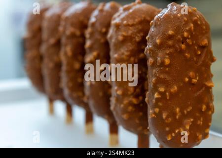 Close-up image of chocolate-covered gelato bars on sticks, resembling ice cream These delicious treats are part of Italian bakery and dessert culture, Stock Photo