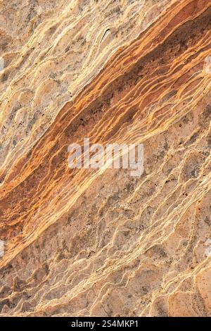 An intricate, natural lines and patterns of golden desert sandstone, emphasizing its rich, warm tones and textured surface. Stock Photo