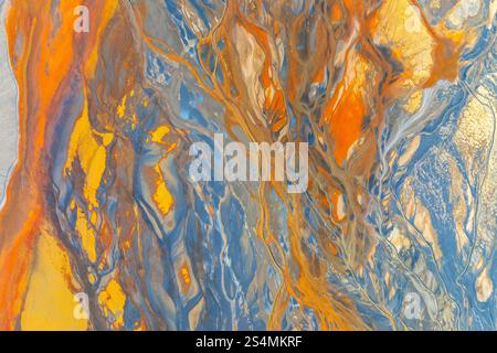 A vibrant abstract image showcasing dynamic swirling patterns in blue, orange, and yellow hues The colors blend seamlessly, creating an artistic and c Stock Photo