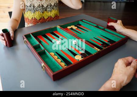 An animated scene of a family playing backgammon on a vibrant, foldable board The image captures dice, checkers and the players' hands, highlighting s Stock Photo