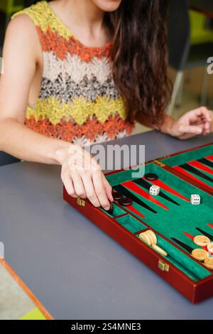 A person concentrates while playing backgammon, with focus on the strategic placement of pieces on the board An engaging scene of skill and leisure at Stock Photo