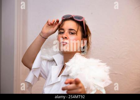 Young woman poses  in stylish outfit with feathered shoulders Stock Photo