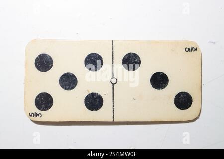 Gosport, Hampshire, England. 1 January 2025. Close up of a wafer thin plastic domino with eight black spots. Stock Photo