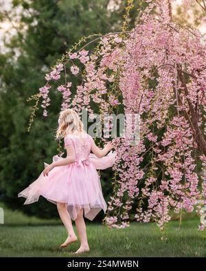 A girl under a Cherry blossom tree at Springtime Stock Photo - Alamy