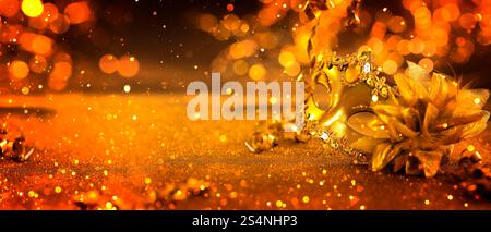 Beautiful carnival mask on golden background with glitter, bokeh effect. Banner design with space for text Stock Photo