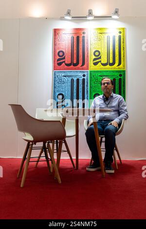 A person sits at a table in front of colorful Islamic wall art Algiers City, Algeria. Stock Photo