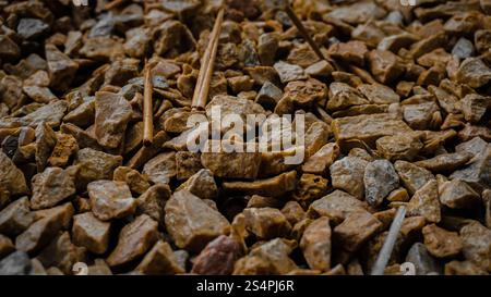 A close-up view of a textured surface covered with small, irregularly shaped stones and gravel, showcasing earthy tones of brown and gray. Stock Photo